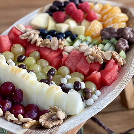 Foto Banadeja de frutas variadas cortadas con frutos secos y frutos secos con chocolates